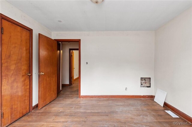 unfurnished room featuring baseboards and wood finished floors