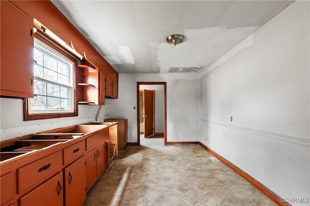 kitchen featuring open shelves, visible vents, and baseboards