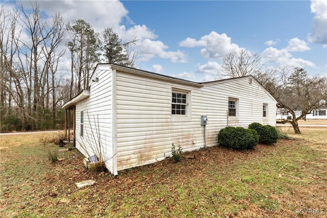 view of side of home with a yard