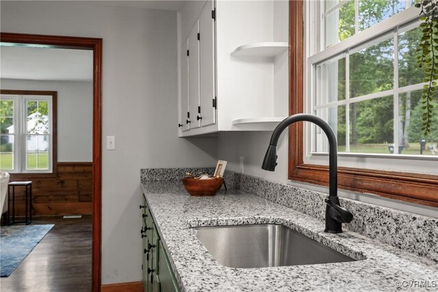 1909 Dinwiddie Ave, Hopewell, VA 23860 - kitchen with wood finished floors, white cabinetry, open shelves, light stone countertops, and wainscoting