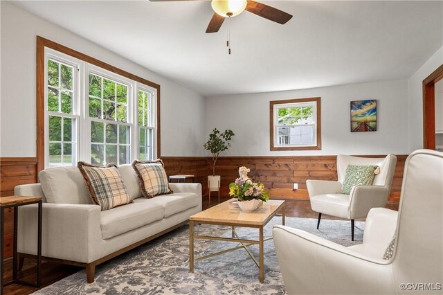 1909 Dinwiddie Ave, Hopewell, VA 23860 - living room featuring a wainscoted wall, wooden walls, a ceiling fan, and wood finished floors