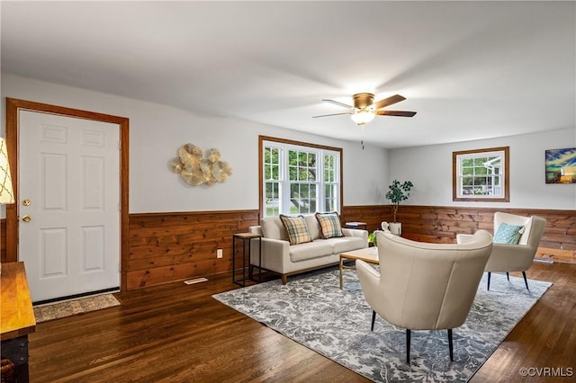 1909 Dinwiddie Ave, Hopewell, VA 23860 - living area with a wainscoted wall, healthy amount of natural light, a ceiling fan, wood finished floors, and wooden walls