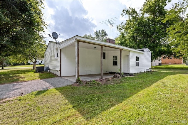 1909 Dinwiddie Ave, Hopewell, VA 23860 - rear view of house featuring a yard, a chimney, an attached carport, and driveway
