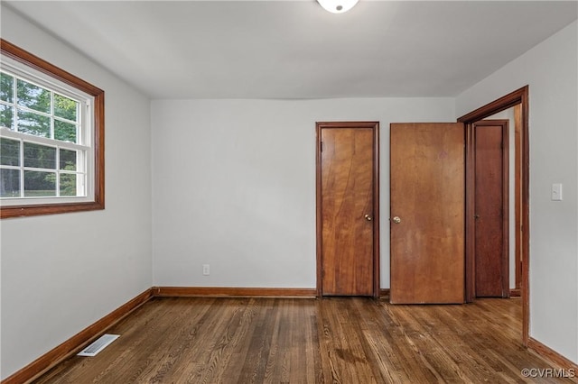 1909 Dinwiddie Ave, Hopewell, VA 23860 - unfurnished bedroom with dark wood-type flooring and multiple closets