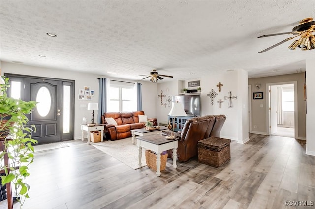 living area featuring light wood-type flooring and a textured ceiling