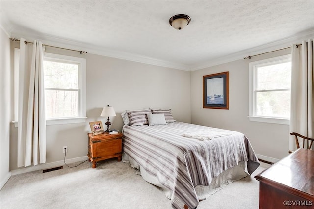 bedroom featuring visible vents, light colored carpet, a textured ceiling, and crown molding