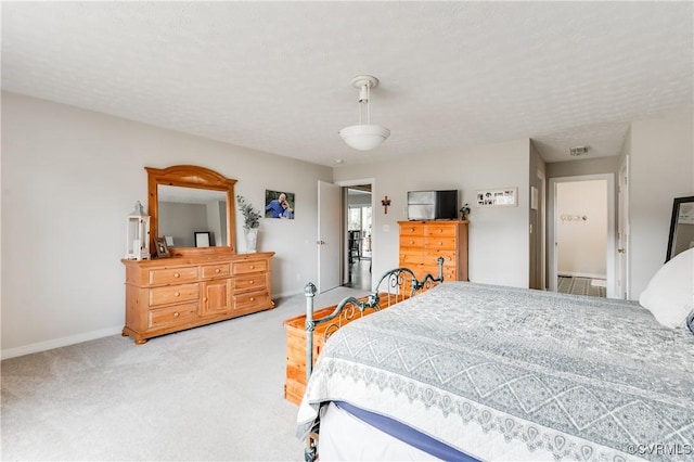 bedroom featuring carpet, baseboards, and a textured ceiling