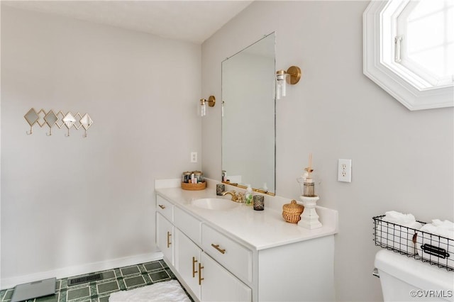 half bath with vanity, toilet, and baseboards