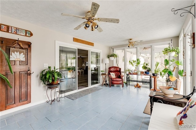 sunroom / solarium featuring a ceiling fan