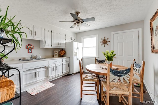 dining space featuring a ceiling fan, baseboards, a textured ceiling, and dark wood-style flooring