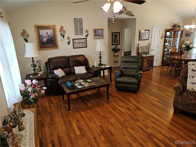 living area with ceiling fan with notable chandelier, lofted ceiling, and wood finished floors