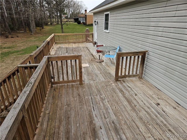 wooden deck featuring a lawn