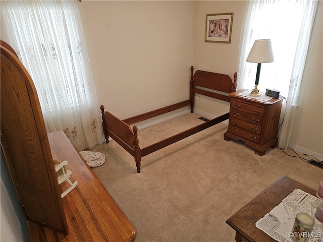 bedroom featuring light carpet and baseboards