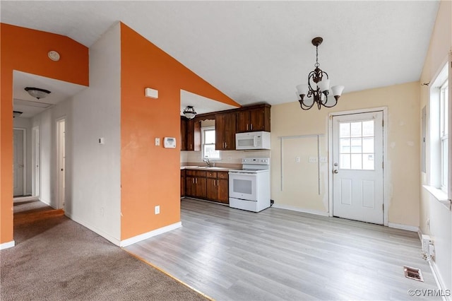 kitchen with white appliances, visible vents, lofted ceiling, light countertops, and a sink