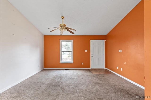 unfurnished room with lofted ceiling, carpet, baseboards, and a ceiling fan