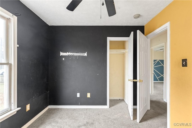 unfurnished bedroom with carpet floors, baseboards, and a ceiling fan