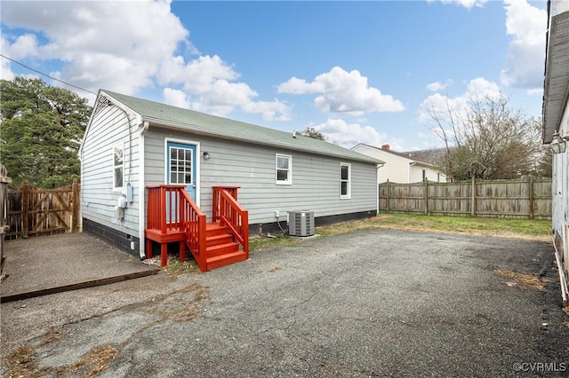 back of property featuring a fenced backyard and central AC unit