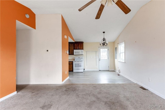 unfurnished living room with carpet floors, baseboards, and high vaulted ceiling