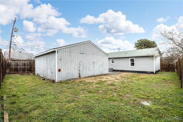 exterior space with an outbuilding, a fenced backyard, a lawn, and central air condition unit