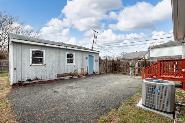 exterior space with an outbuilding, a fenced backyard, and cooling unit