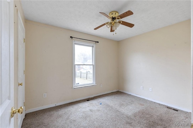 carpeted spare room with a ceiling fan, visible vents, a textured ceiling, and baseboards