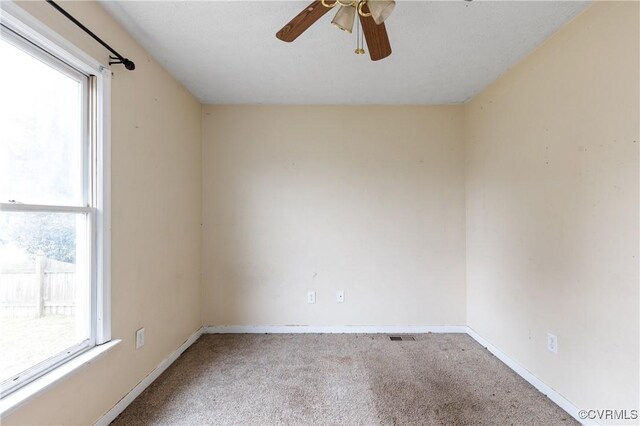 unfurnished room featuring a ceiling fan, baseboards, a wealth of natural light, and carpet flooring