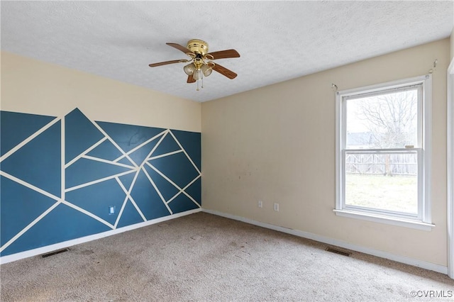 unfurnished room with a textured ceiling, plenty of natural light, and visible vents