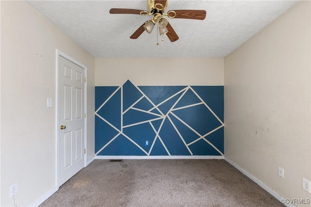 spare room with a ceiling fan, carpet, a textured ceiling, and baseboards