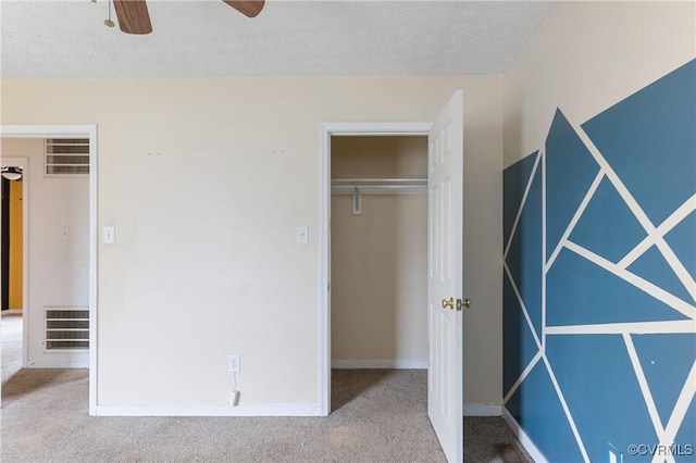 unfurnished bedroom featuring carpet floors, baseboards, visible vents, and a textured ceiling