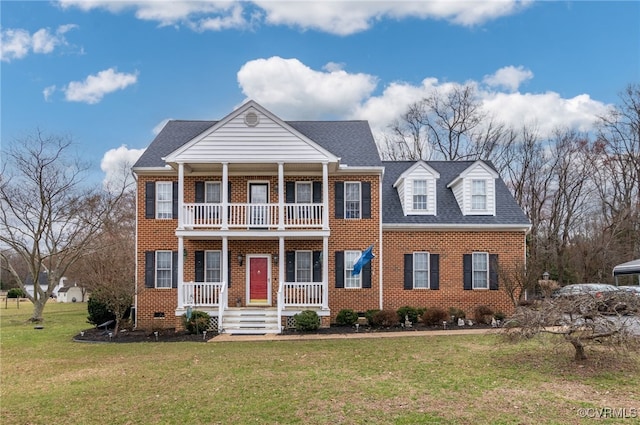 neoclassical home featuring brick siding, a porch, a shingled roof, a front yard, and a balcony