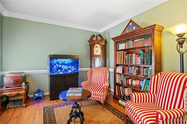 living area featuring baseboards, wood finished floors, and crown molding