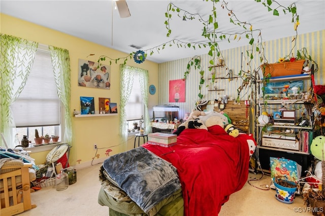 carpeted bedroom with visible vents and a ceiling fan