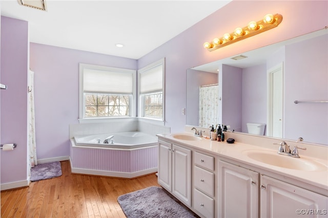 full bathroom with visible vents, a sink, hardwood / wood-style floors, and double vanity