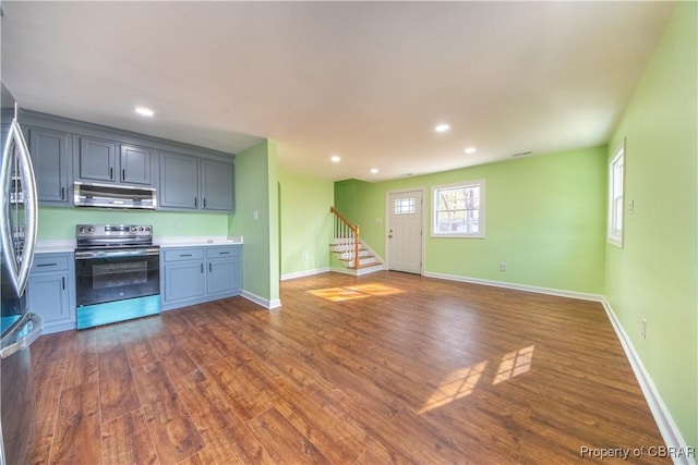 kitchen featuring baseboards, appliances with stainless steel finishes, light countertops, and dark wood-type flooring