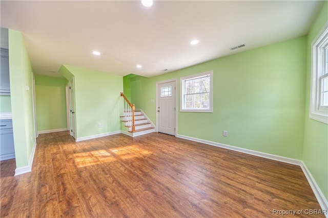 spare room with recessed lighting, visible vents, wood finished floors, baseboards, and stairs