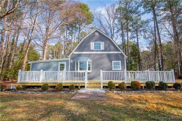 back of house featuring a yard, a deck, and a gambrel roof