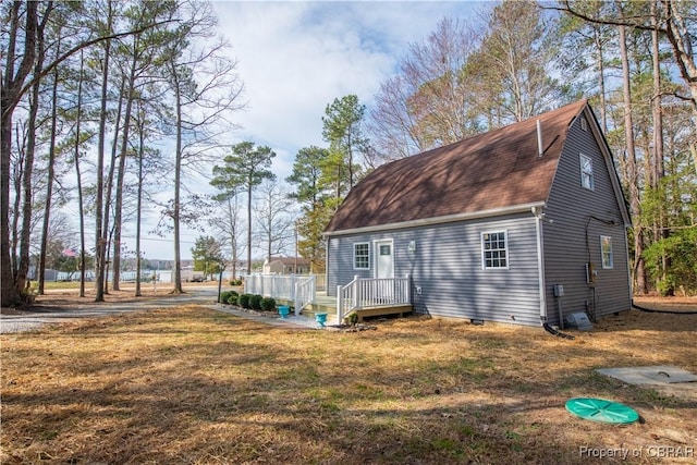 view of front of property with roof with shingles, crawl space, a front yard, and a wooden deck