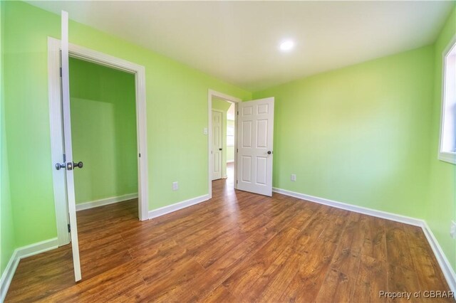 unfurnished bedroom with baseboards and wood finished floors