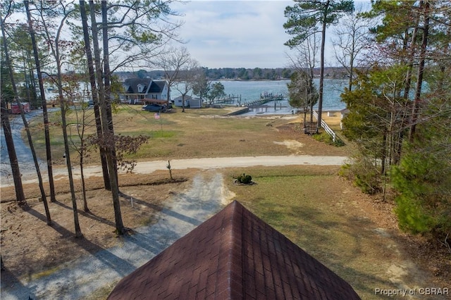 view of yard featuring a water view and dirt driveway