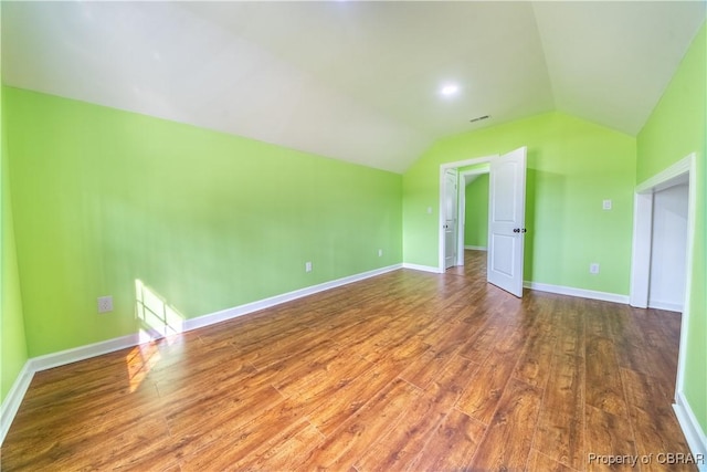 additional living space featuring visible vents, vaulted ceiling, baseboards, and wood finished floors