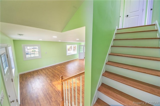 staircase with lofted ceiling, recessed lighting, wood finished floors, visible vents, and baseboards