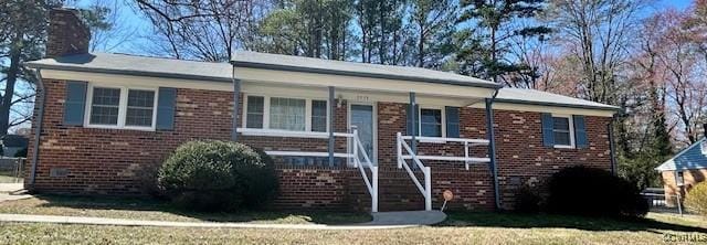 single story home featuring brick siding, a porch, and a chimney