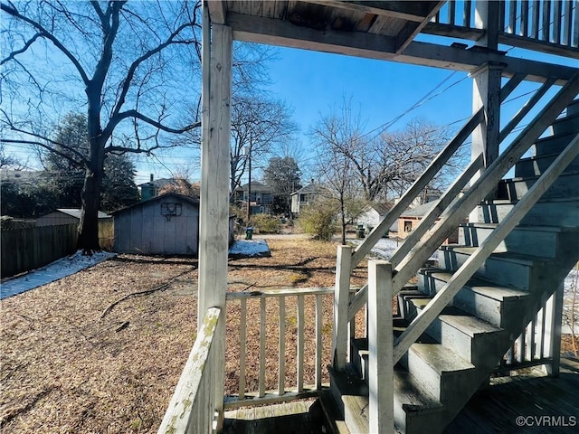 view of yard with an outbuilding, fence, stairway, and a storage shed