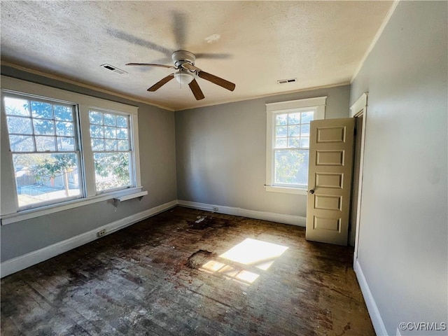 spare room featuring baseboards, a textured ceiling, visible vents, and crown molding