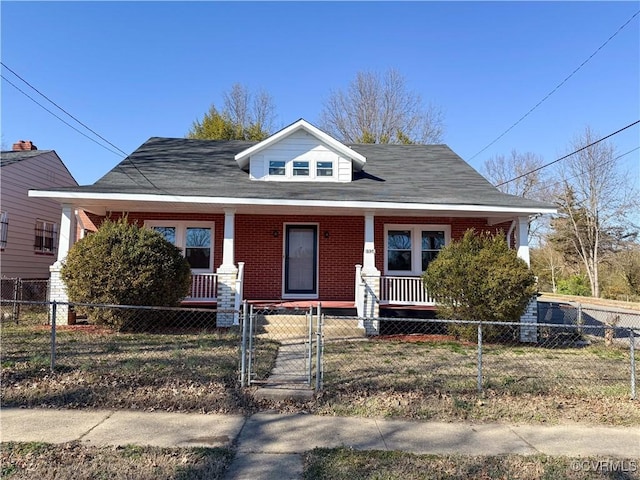 bungalow featuring a fenced front yard, brick siding, covered porch, and a gate