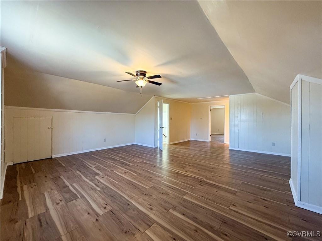 bonus room featuring vaulted ceiling, wood finished floors, baseboards, and ceiling fan