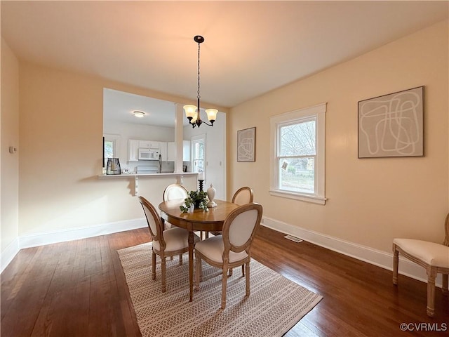 1934 Wood St, Richmond, VA 23223 - dining space with dark wood-type flooring, a notable chandelier, baseboards, and visible vents