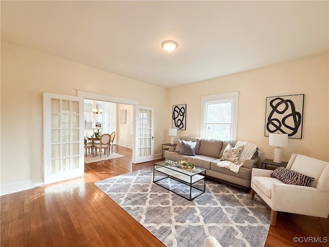 1934 Wood St, Richmond, VA 23223 - living room with an inviting chandelier, hardwood / wood-style flooring, and baseboards