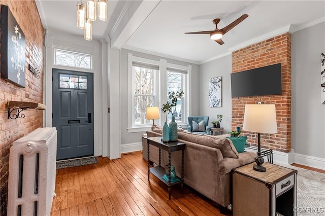 living area with a healthy amount of sunlight, radiator heating unit, and ornamental molding