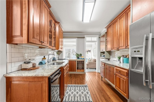 kitchen with black dishwasher, stainless steel fridge with ice dispenser, and brown cabinets